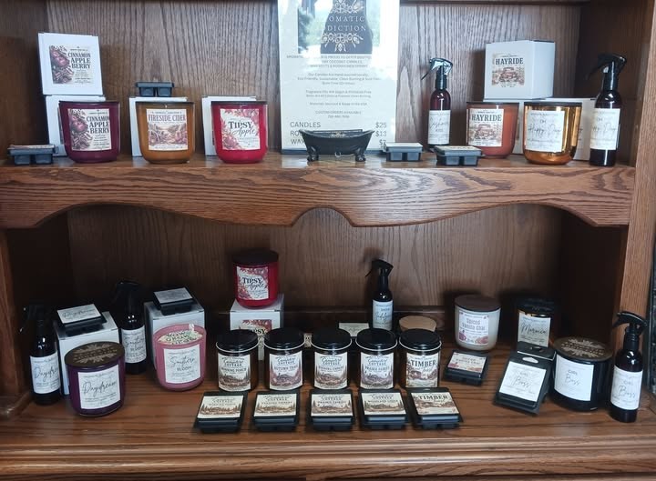 Aromatic Addiction candles, wax melts and room sprays on a wooden shelf